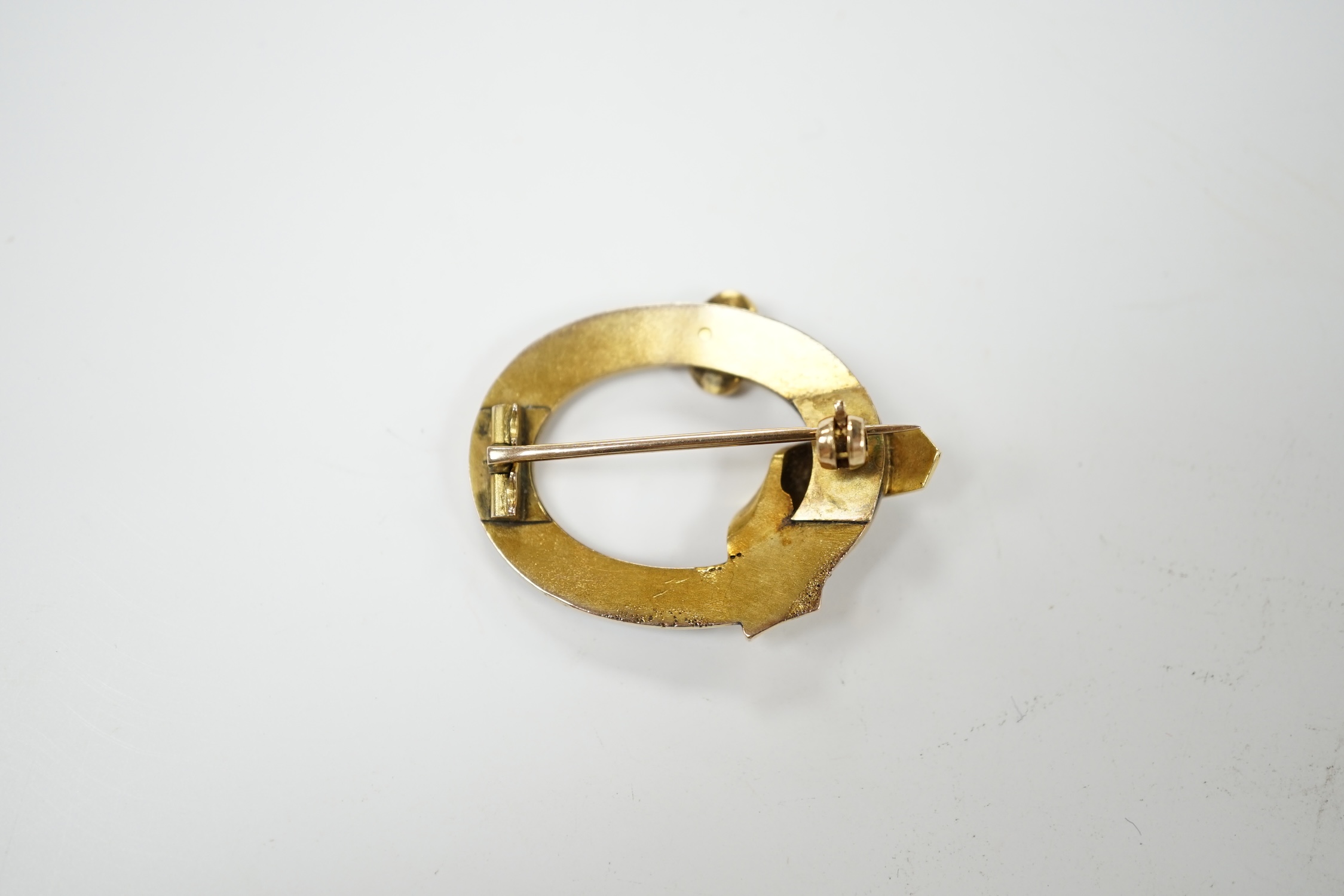 A late Victorian yellow metal, split pearl and enamel set open work buckle brooch, 34mm, gross weight 7.6 grams. Condition - fair to poor